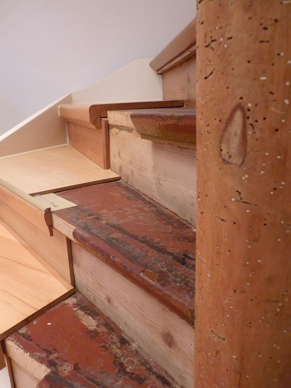 Eine Nahaufnahme einer Holztreppe mit einer kaputten Stufe