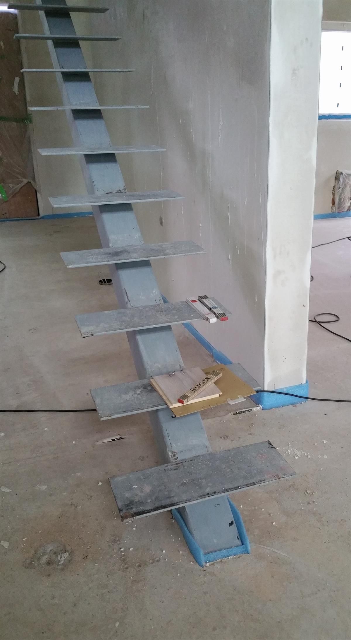 In einem Raum wird eine Metalltreppe eingebaut.