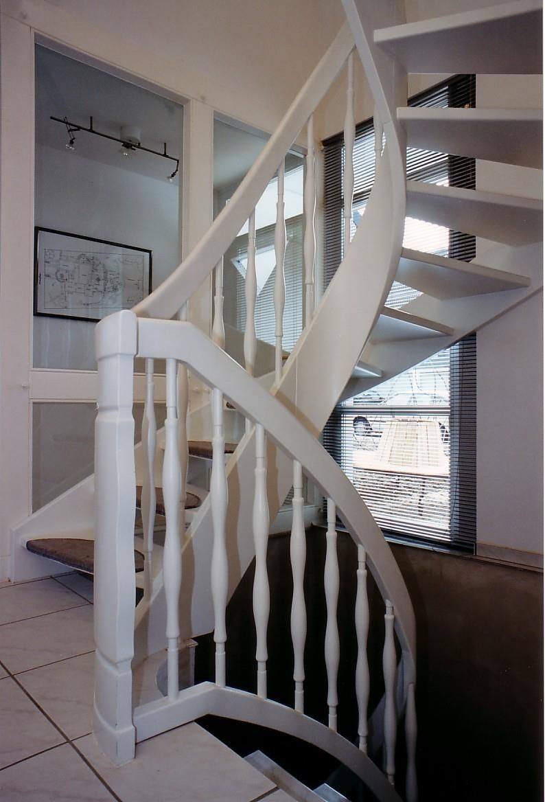 Eine Wendeltreppe mit einem weißen Geländer in einem Haus