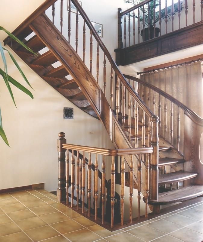 Eine Holztreppe mit Metallgeländer, die in den zweiten Stock führt