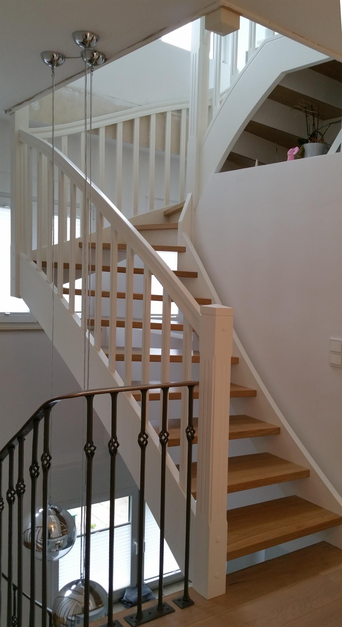 Eine Treppe mit Holzstufen und einem weißen Geländer in einem Haus.