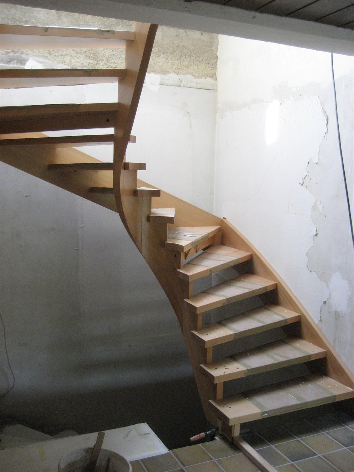 Eine Holztreppe in einem Raum mit einer weißen Wand