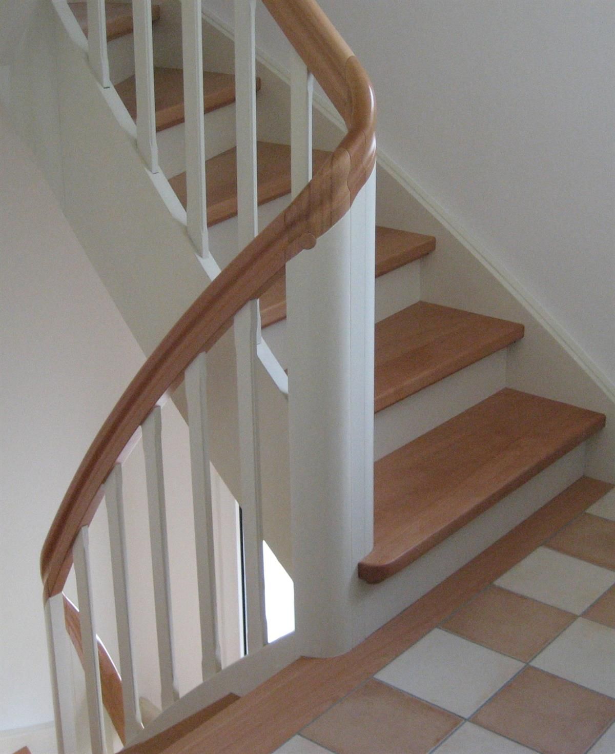 Eine Treppe mit Holzstufen und einem weißen Geländer