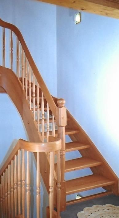 Eine Holztreppe mit einer blauen Wand und einem Teppich auf dem Boden