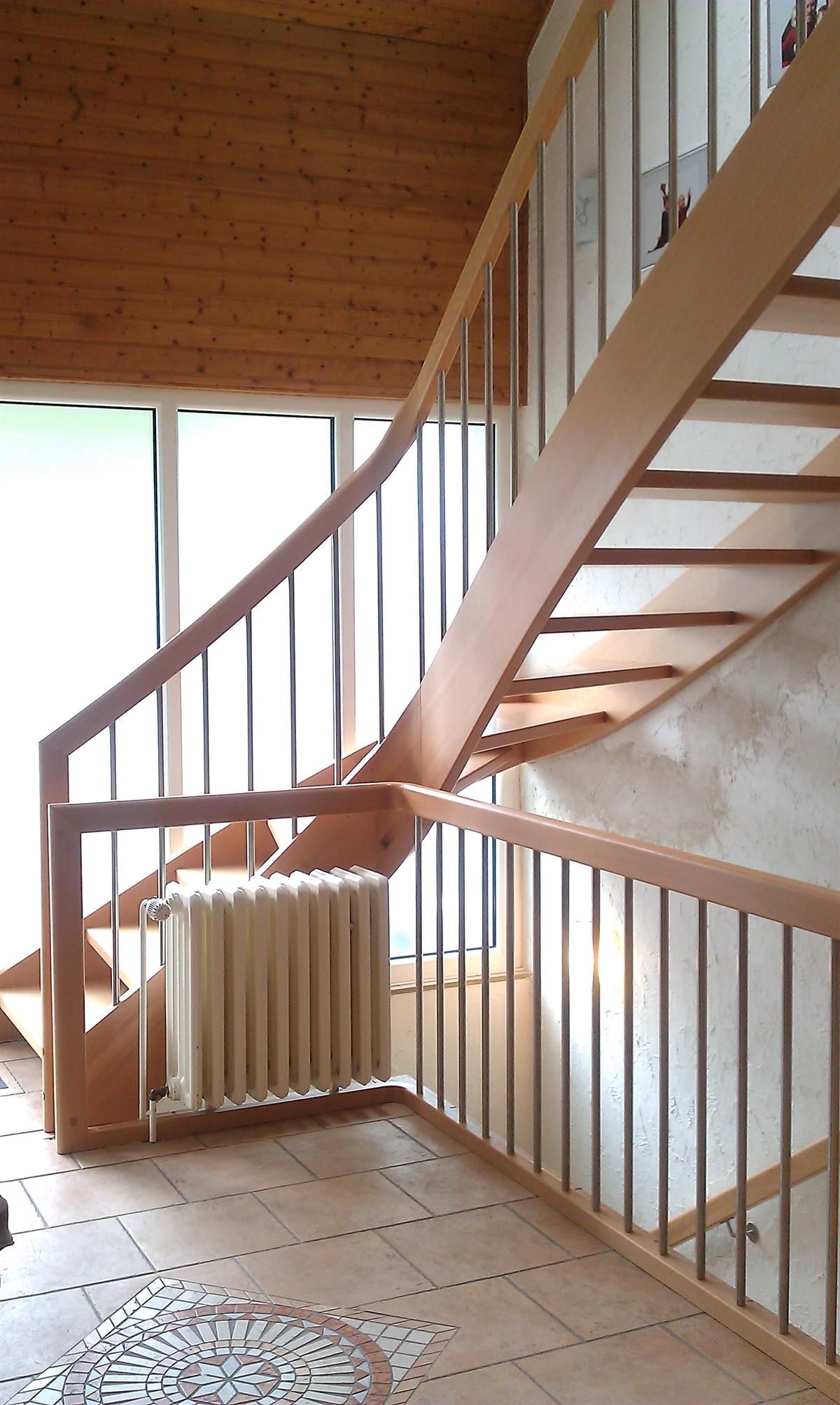 Eine Holztreppe mit einem Heizkörper darunter