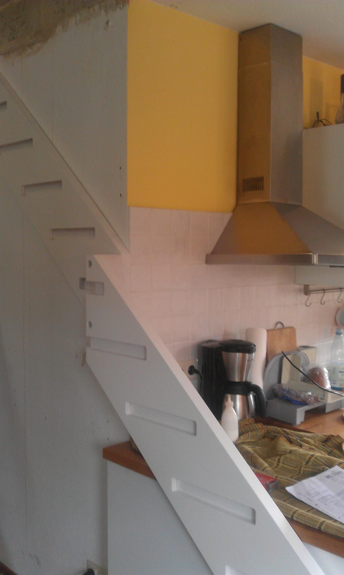 Eine Küche mit einer Treppe, die nach oben führt