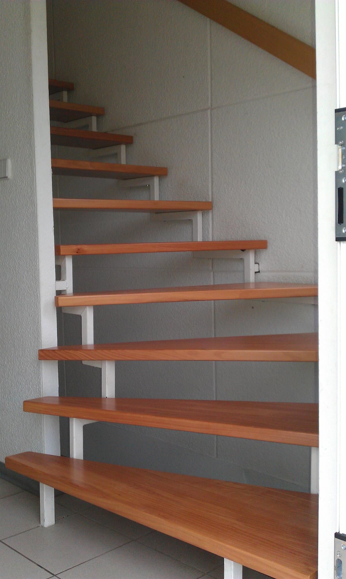 Eine Reihe von Holztreppen mit einem weißen Geländer