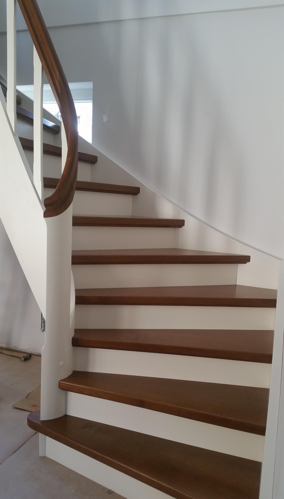 Eine Treppe mit Holzstufen und weißem Geländer