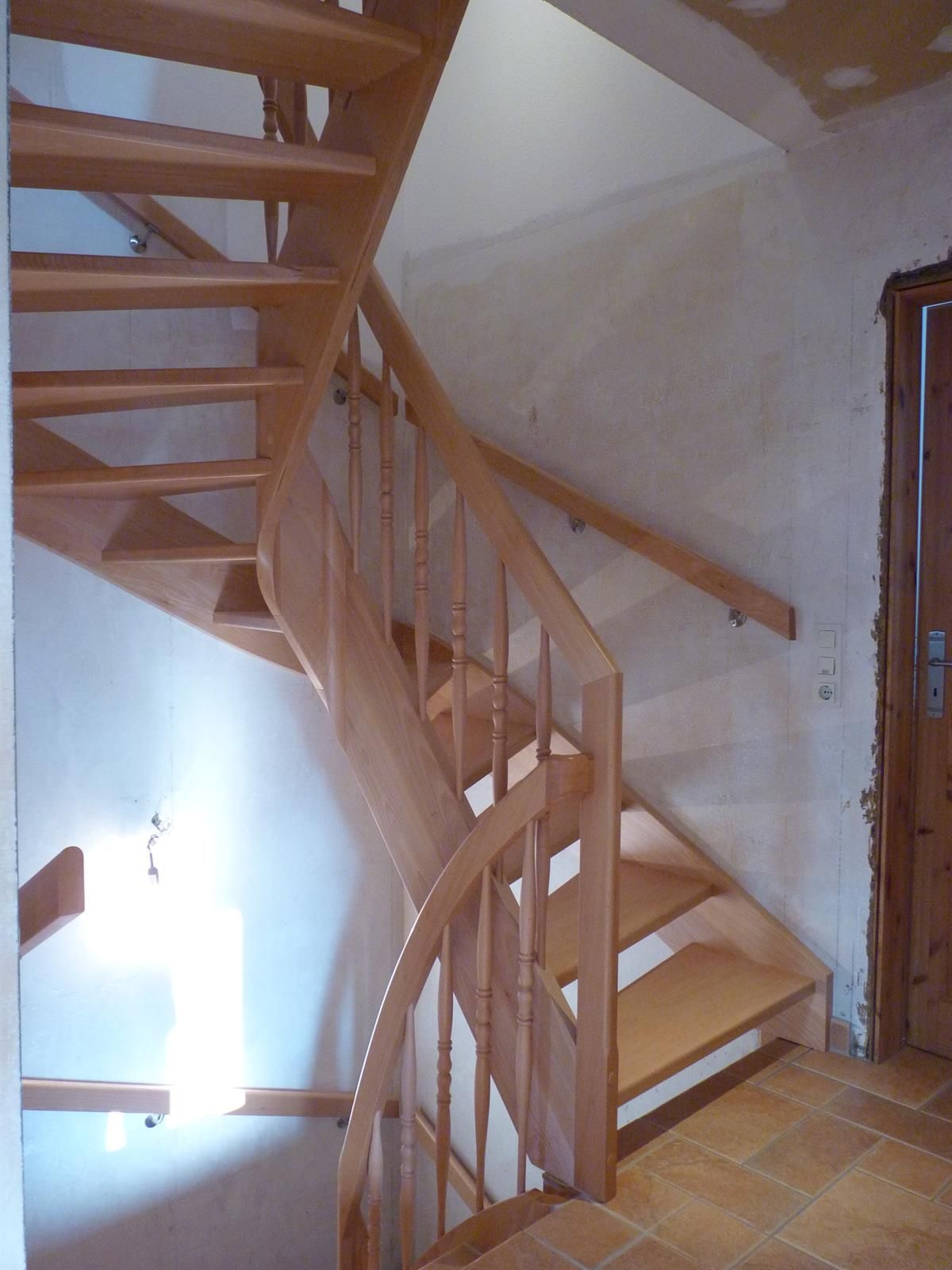 Eine hölzerne Wendeltreppe mit einem hölzernen Geländer