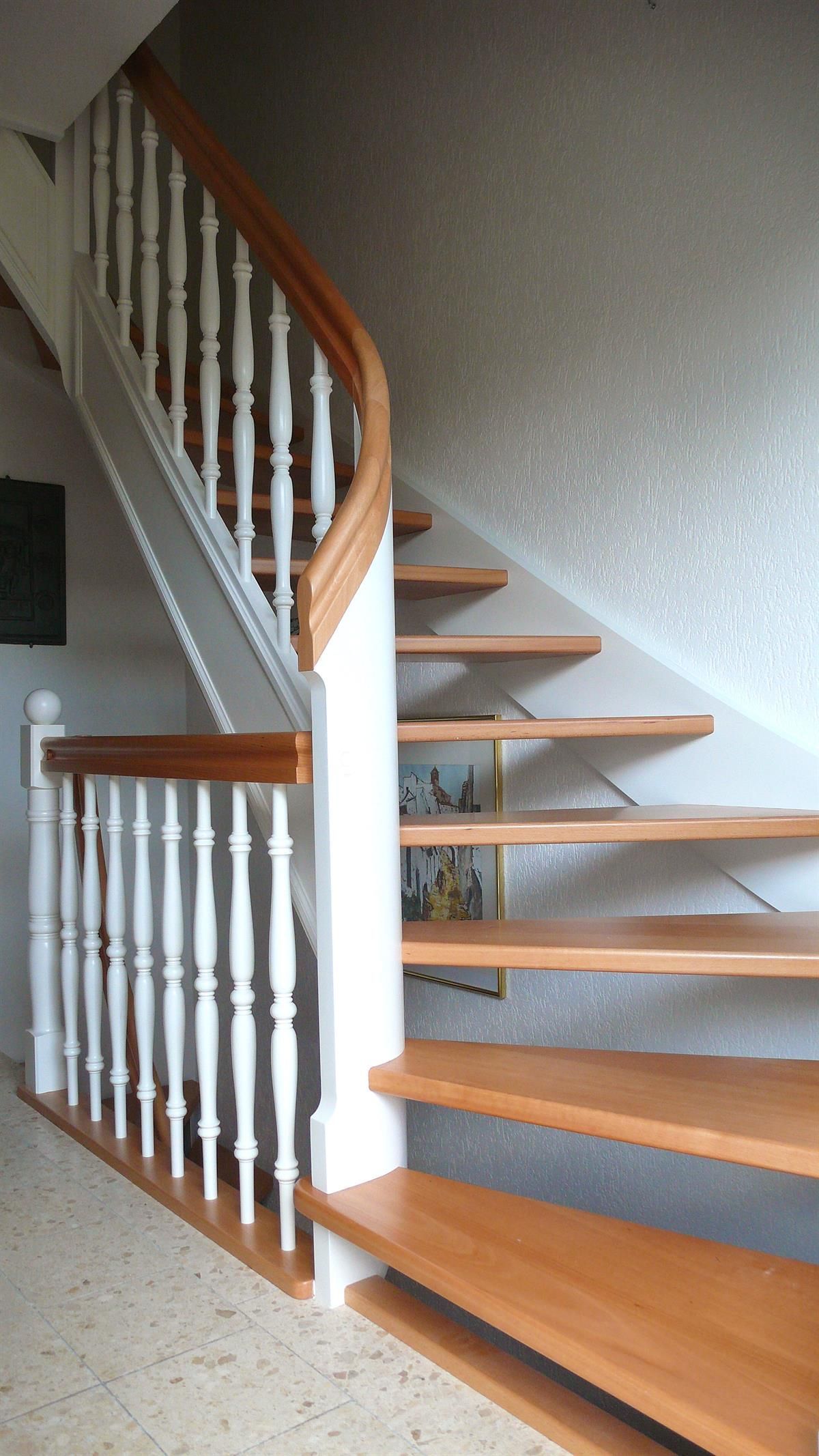 Eine Holztreppe mit weißem Geländer und Holzstufen