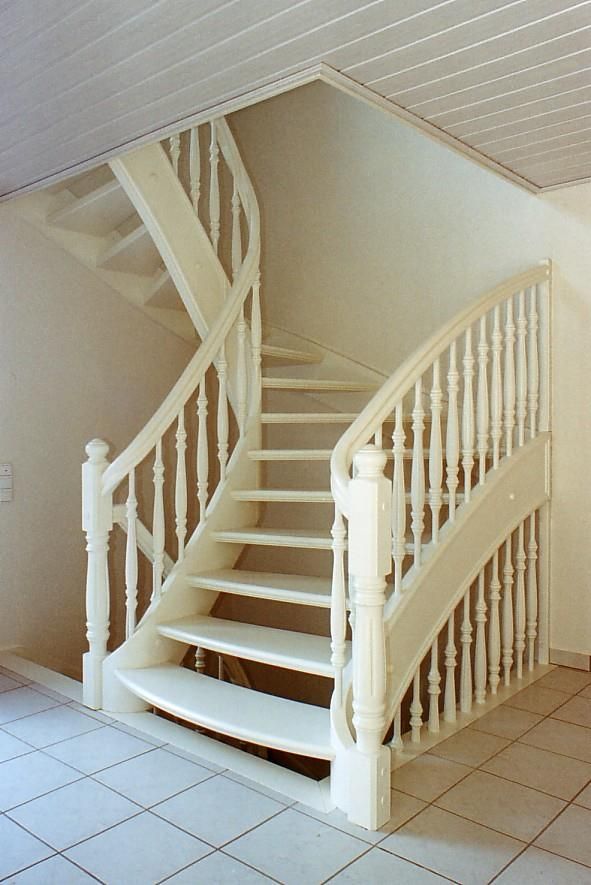 Eine weiße Holztreppe mit geschwungenem Geländer
