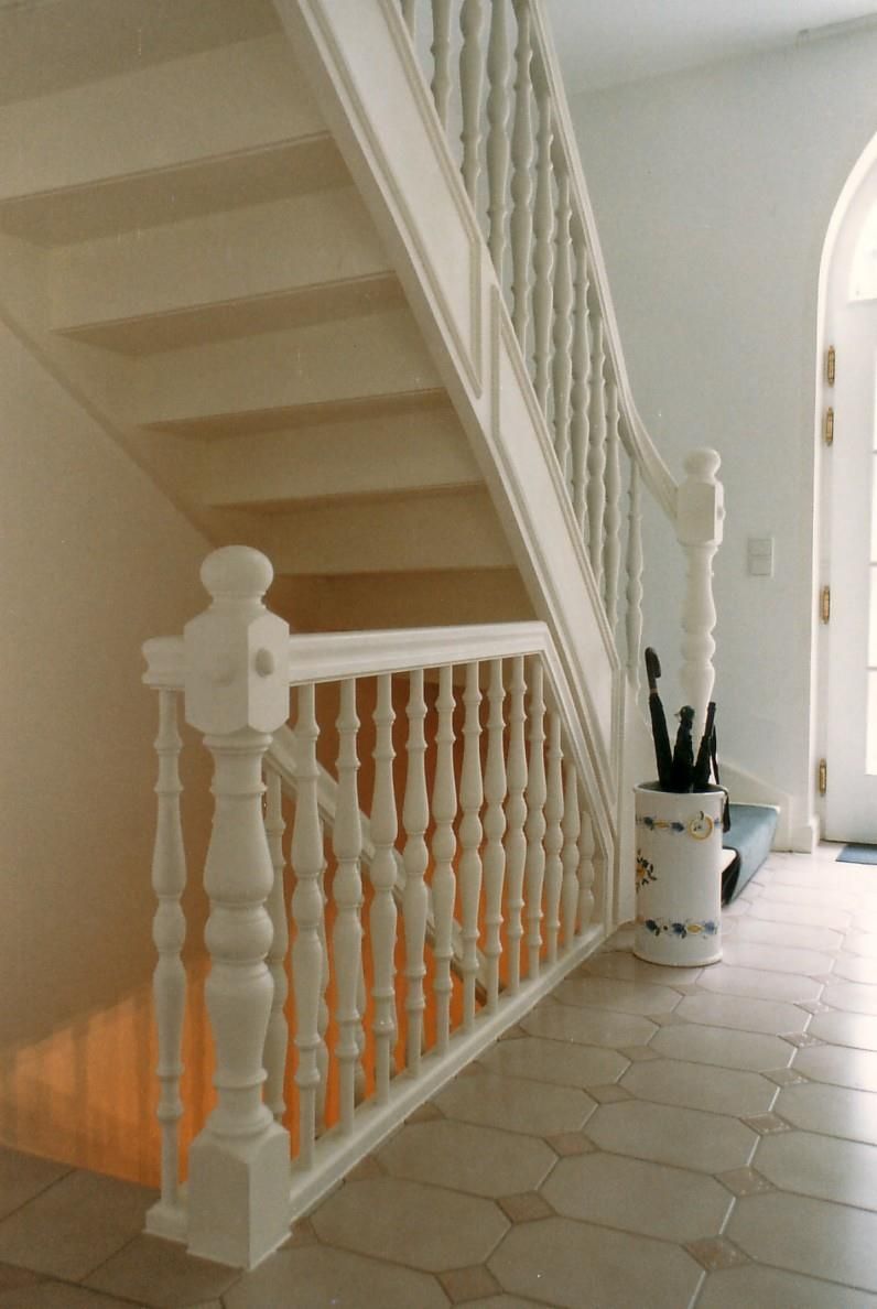 Eine Treppe mit einem weißen Geländer in einem Flur