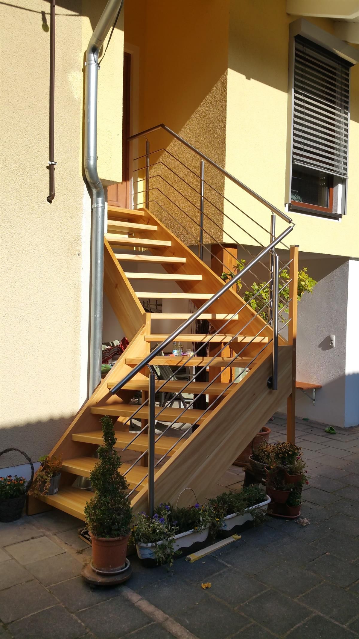 Eine Holztreppe mit Edelstahlgeländer