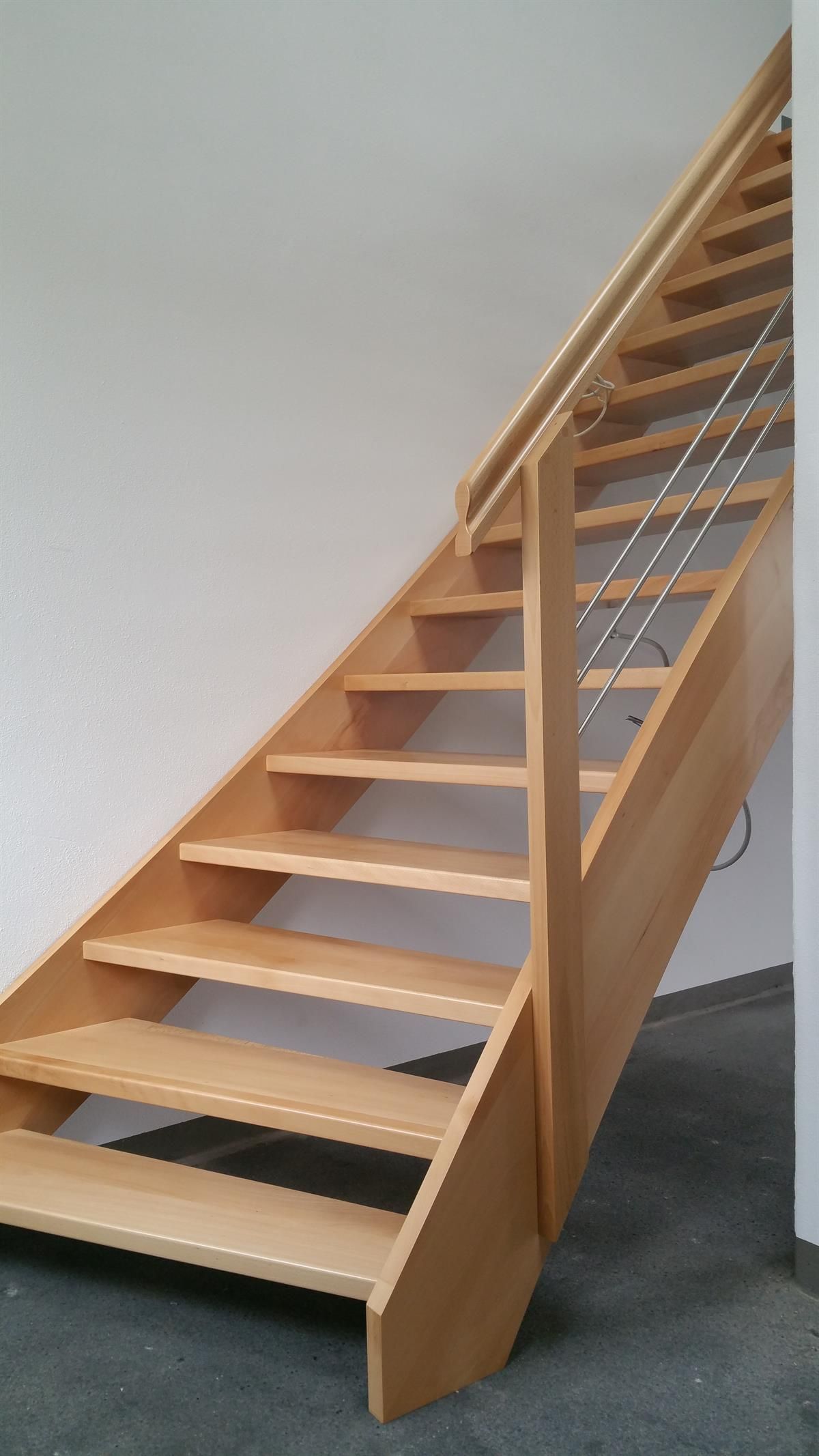 Eine Holztreppe mit Metallgeländer, die in den zweiten Stock führt