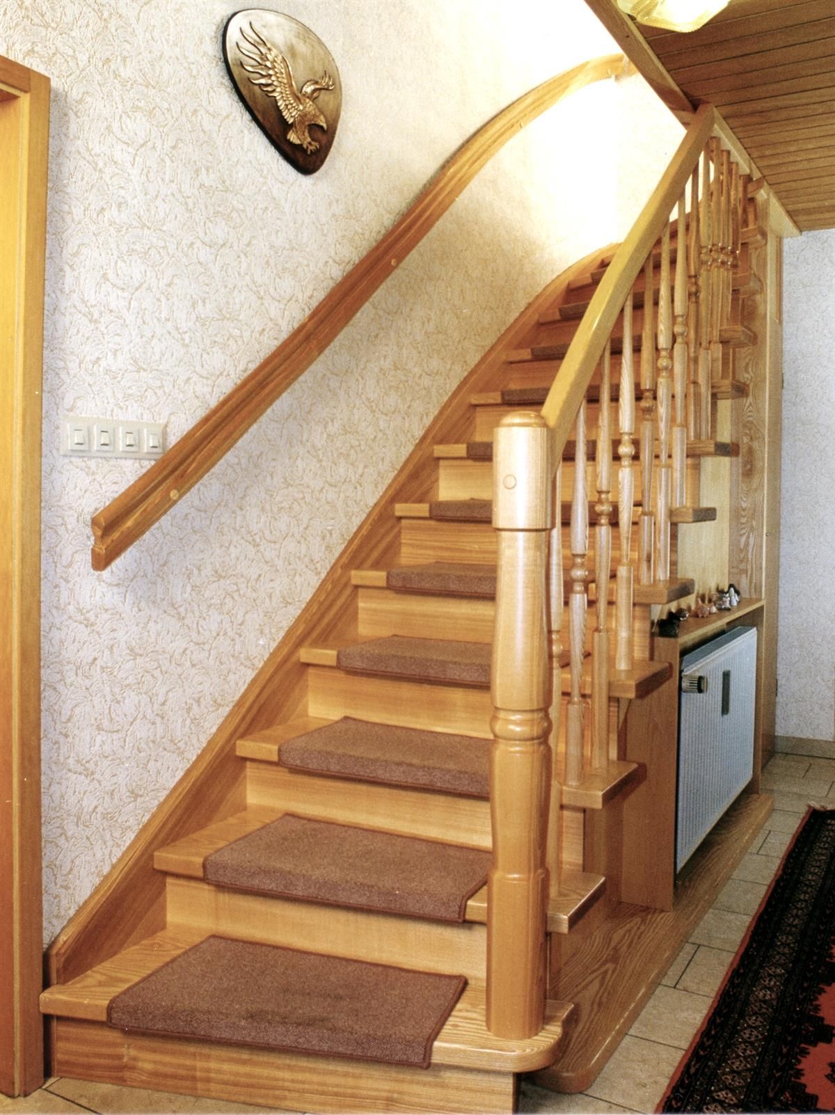 Eine Holztreppe mit einem Teppich auf den Stufen