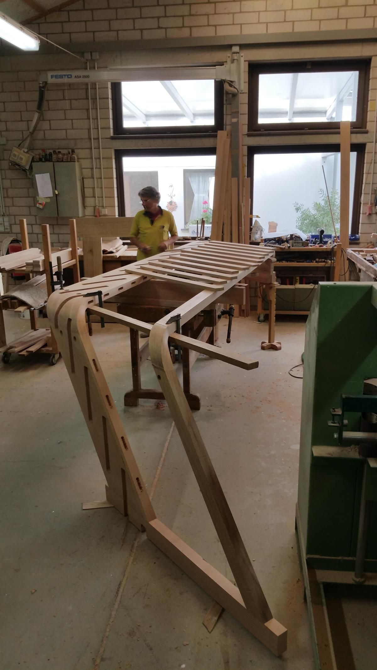 Ein Mann arbeitet in einer Werkstatt an einem Stück Holz