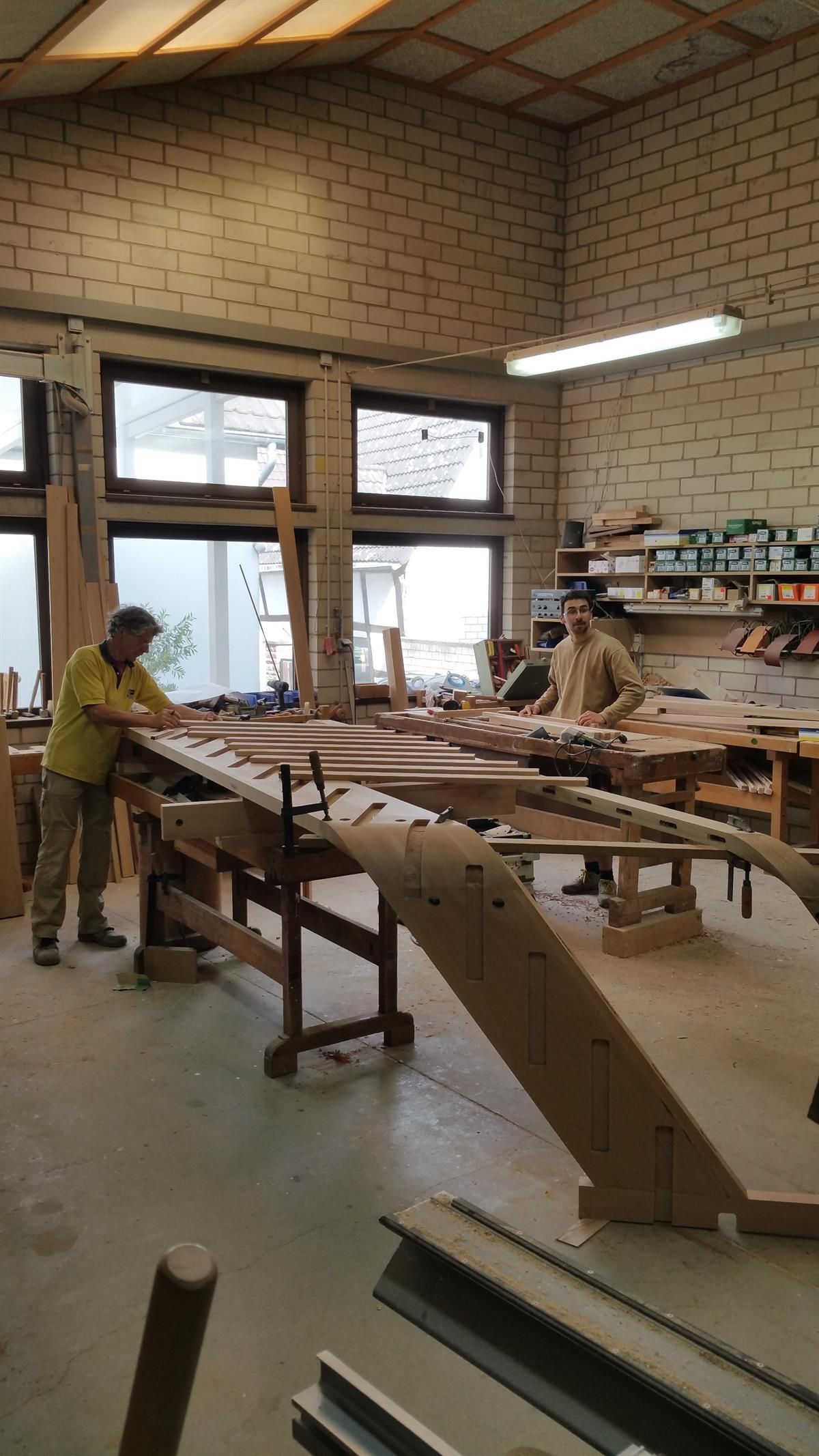 Ein Mann arbeitet in einer Werkstatt an einem Stück Holz