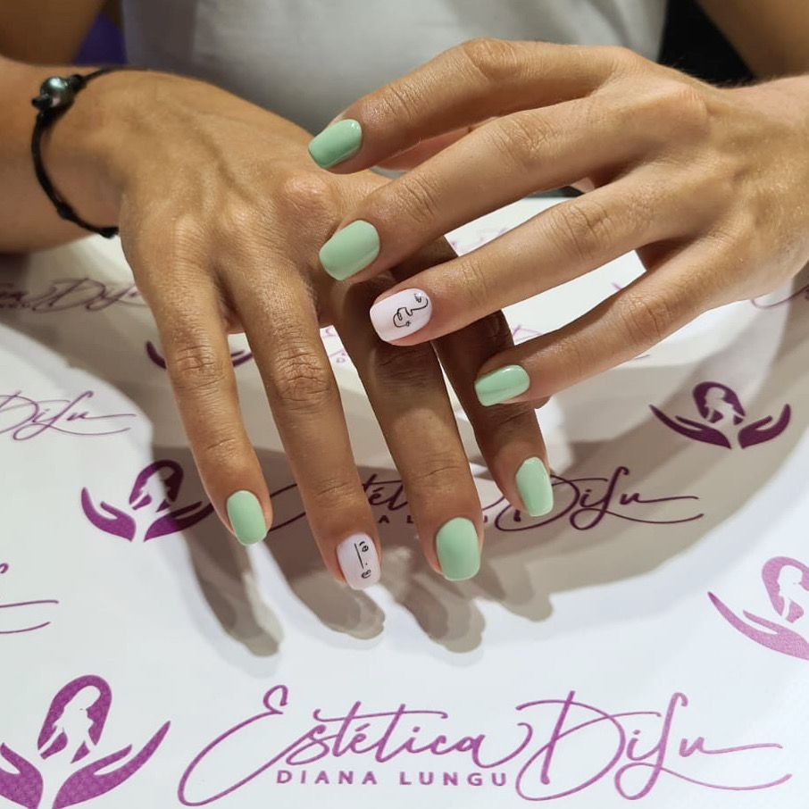 Un primer plano de las manos de una mujer con uñas verdes.