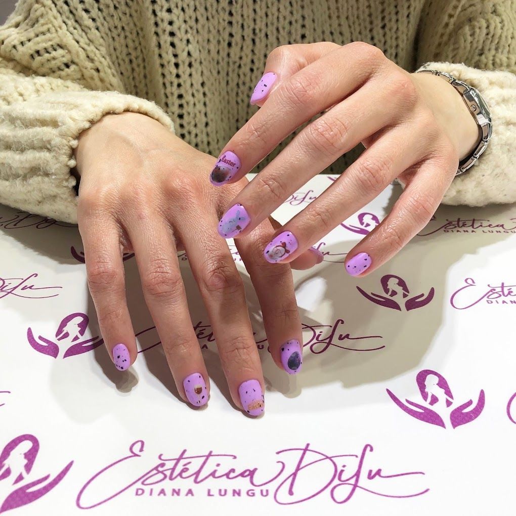 Un primer plano de las manos de una mujer con uñas moradas.