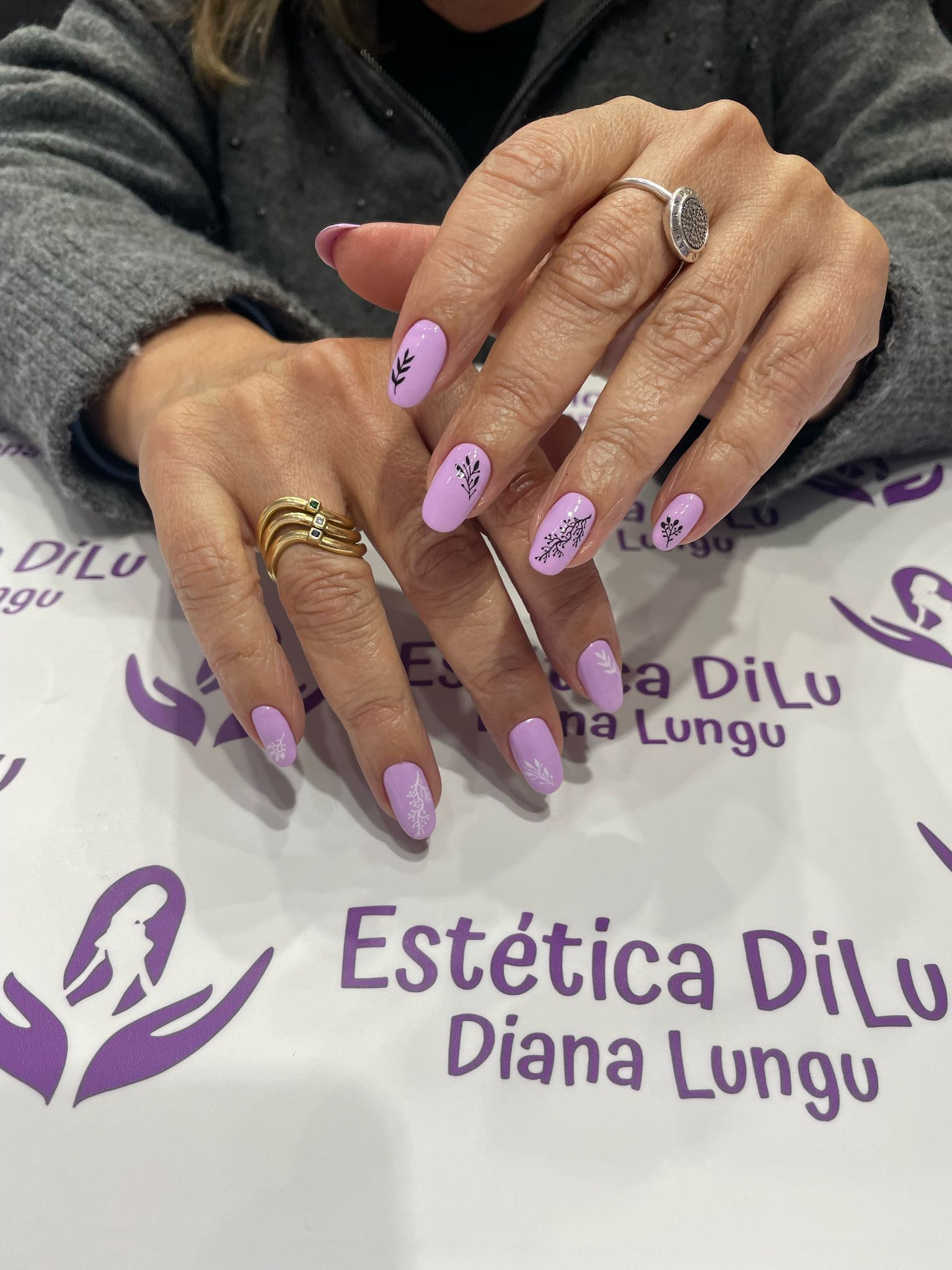 Un primer plano de las manos de una mujer con uñas moradas.