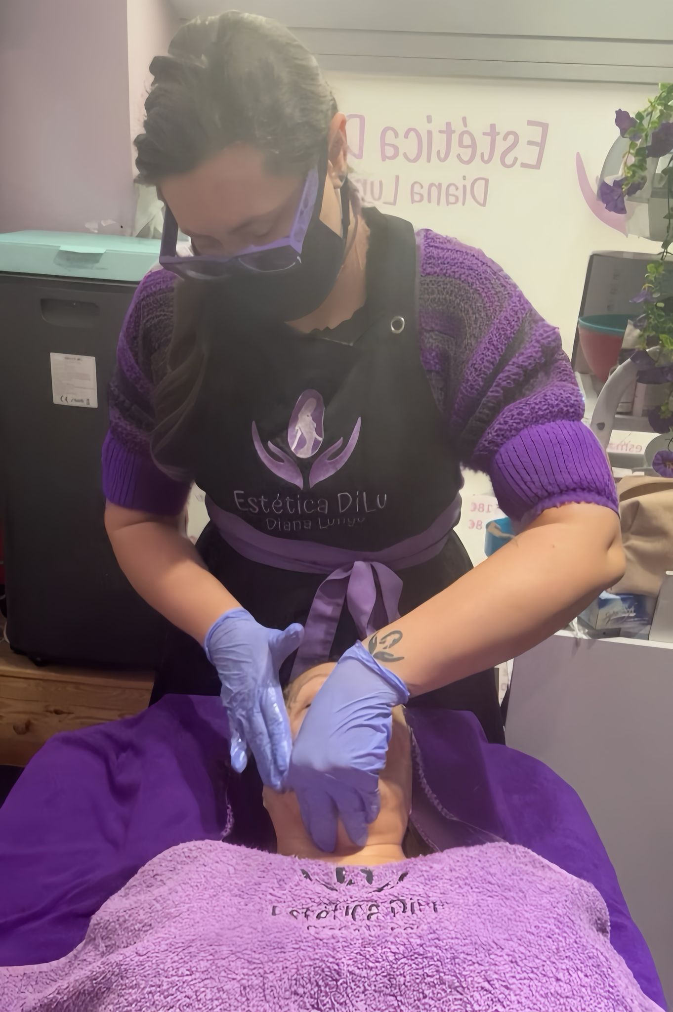 Una mujer con mascarilla y guantes está dando un masaje a una mujer.