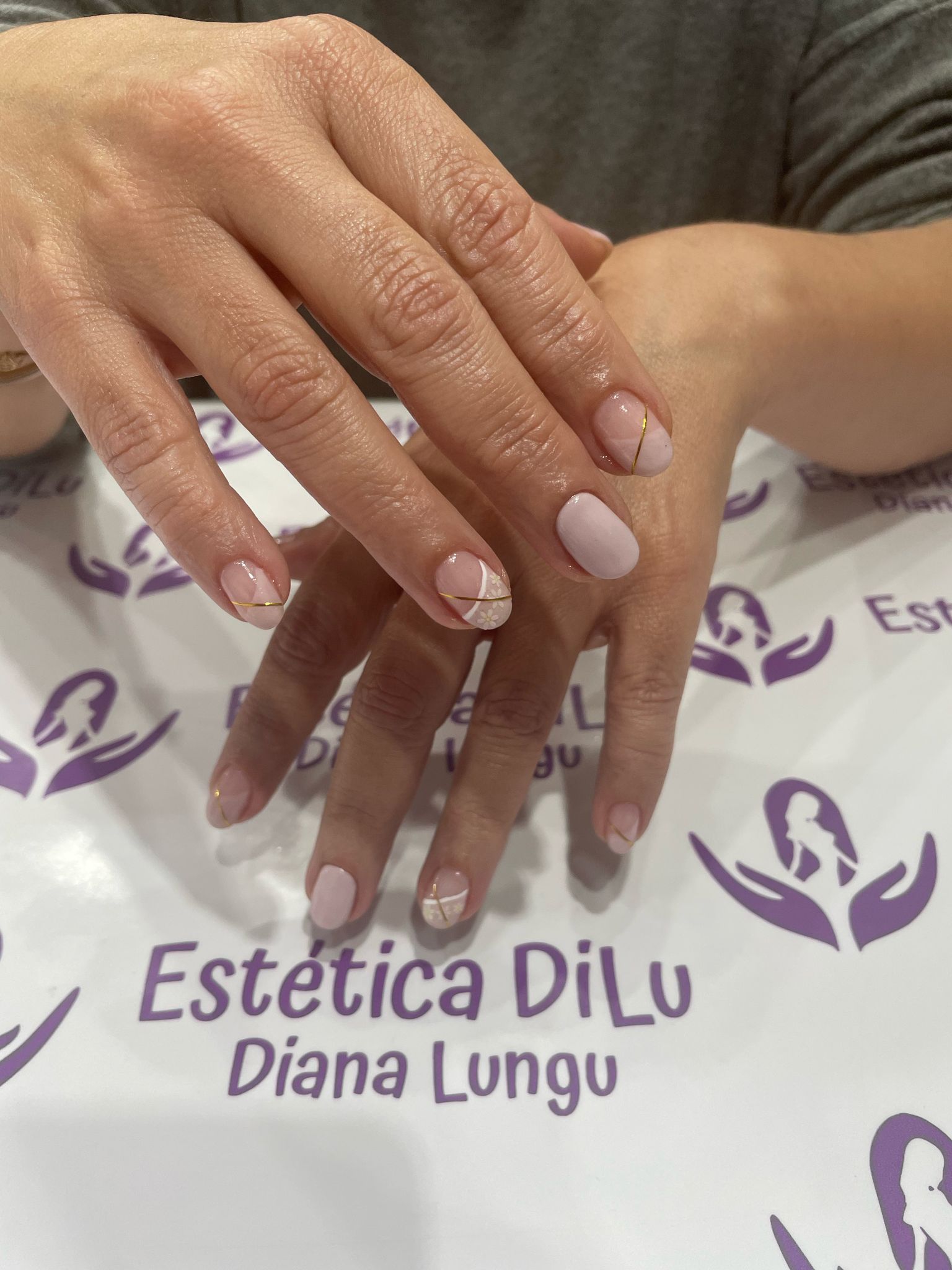 Un primer plano de las uñas de una mujer con las palabras estetica dilu diana lungu en la parte inferior.