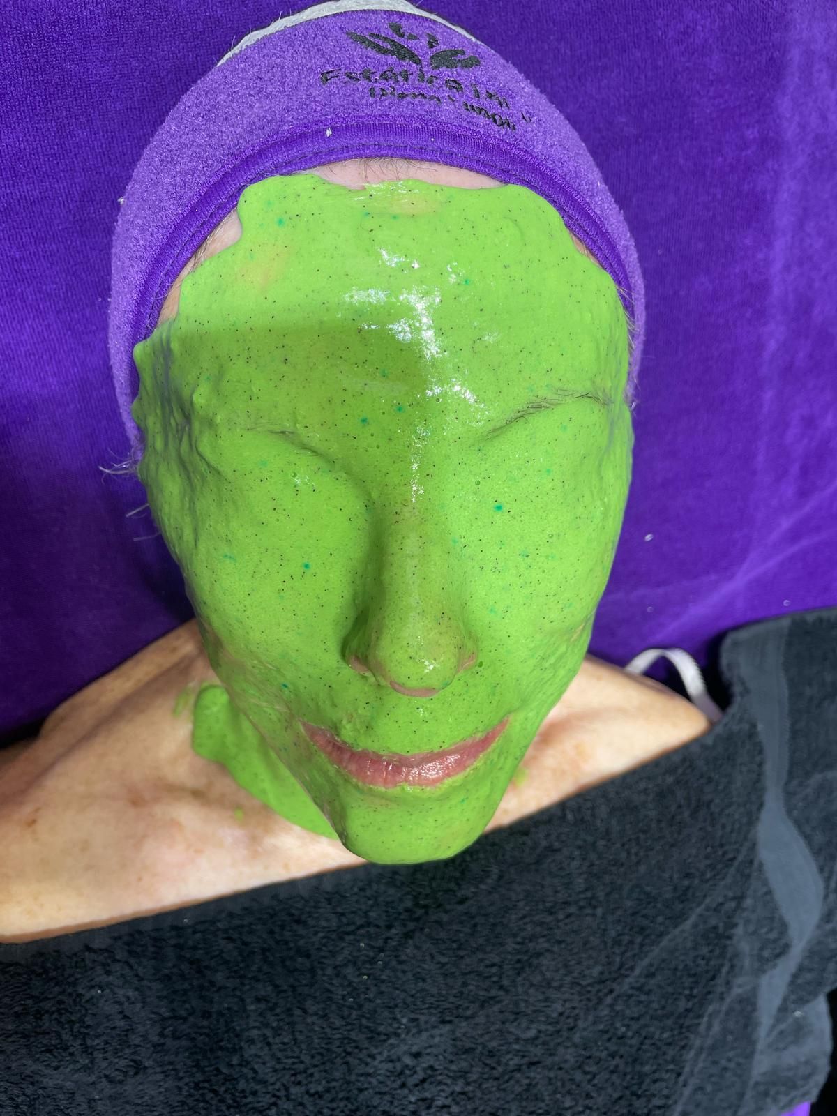 Una mujer lleva una máscara verde en su cara.