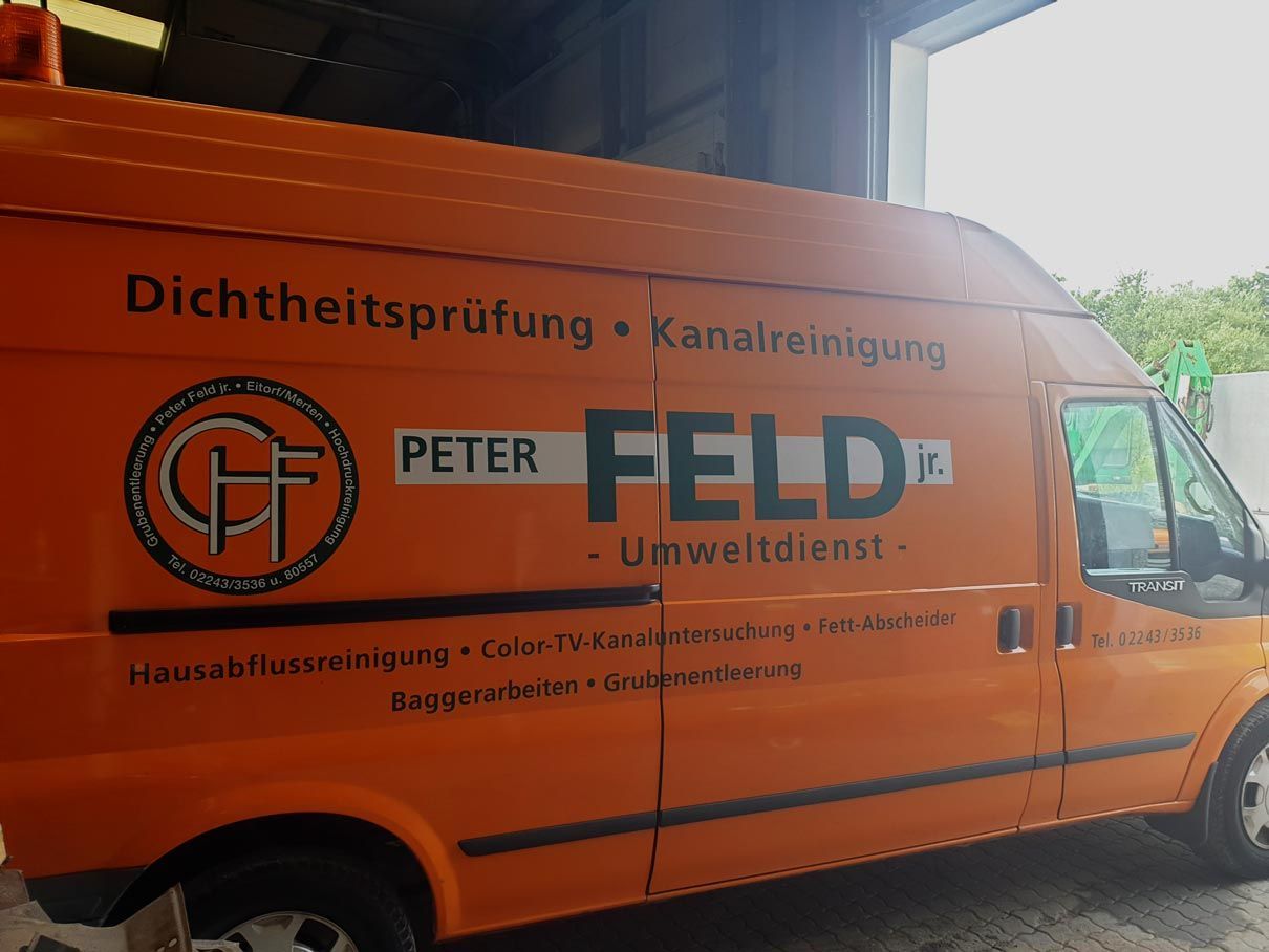 Ein orangefarbener Lieferwagen mit dem Namen Peter Feld darauf