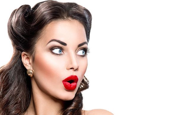 Una mujer con lápiz labial rojo está haciendo una cara de sorpresa.