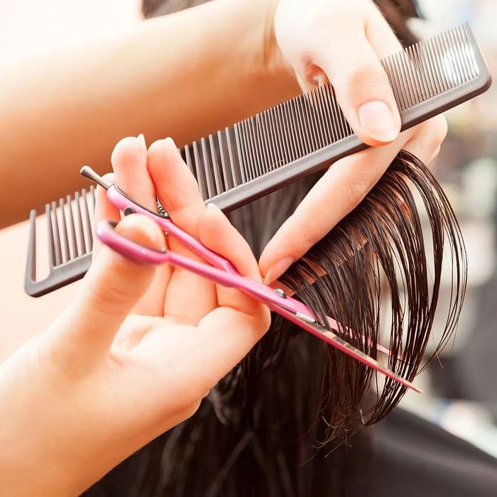 Una mujer se está cortando el pelo en la peluquería.