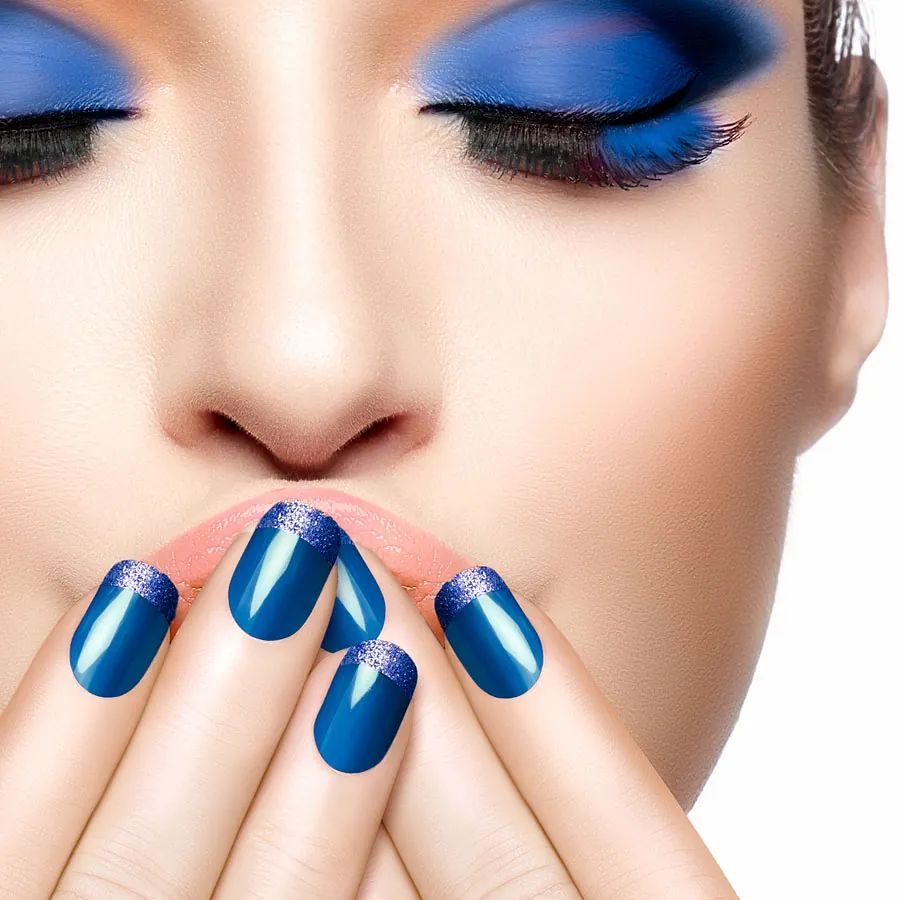 Un primer plano del rostro de una mujer con uñas azules.