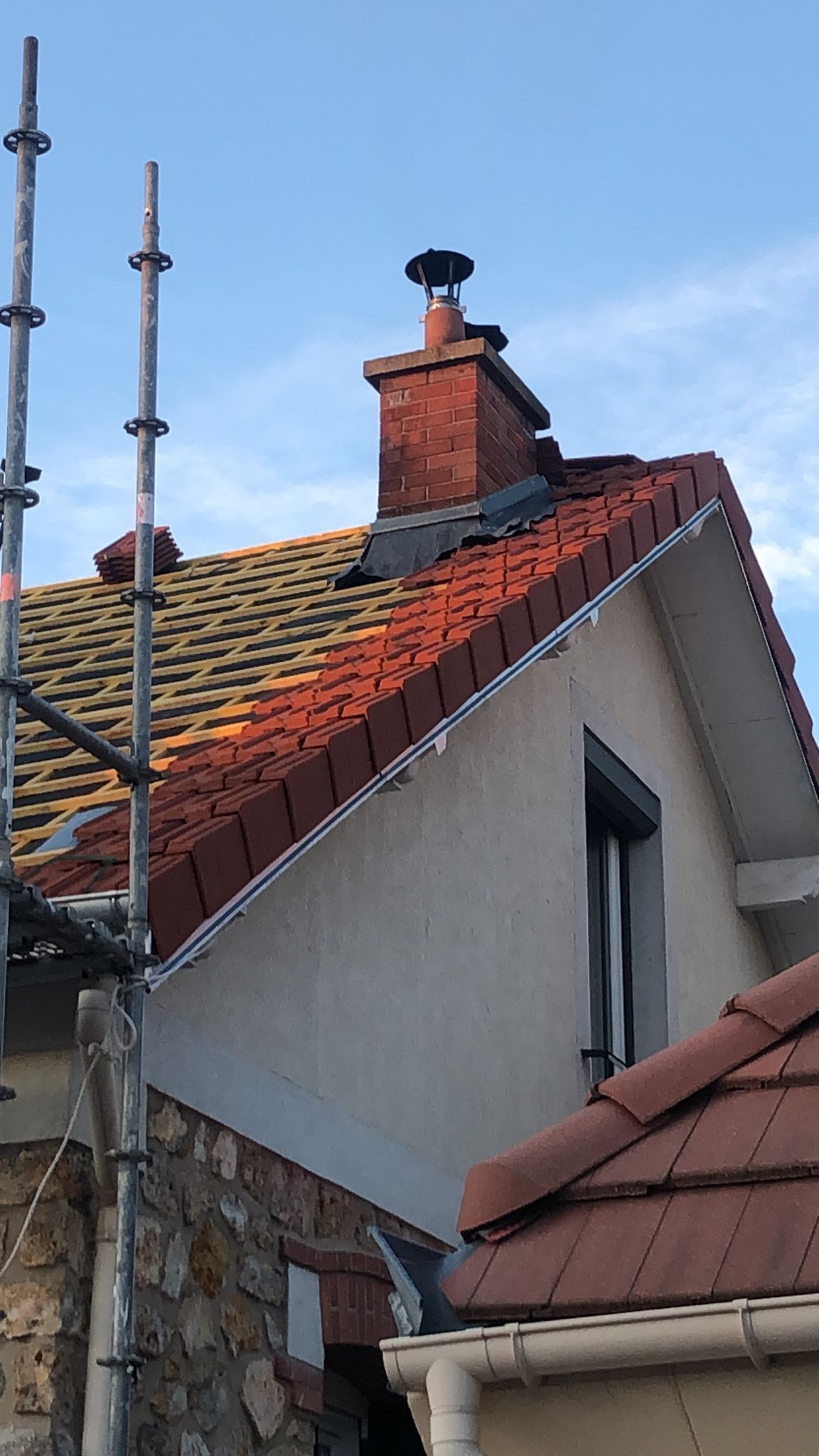 Des travaux de rénovation d'une couverture de toit en tuiles