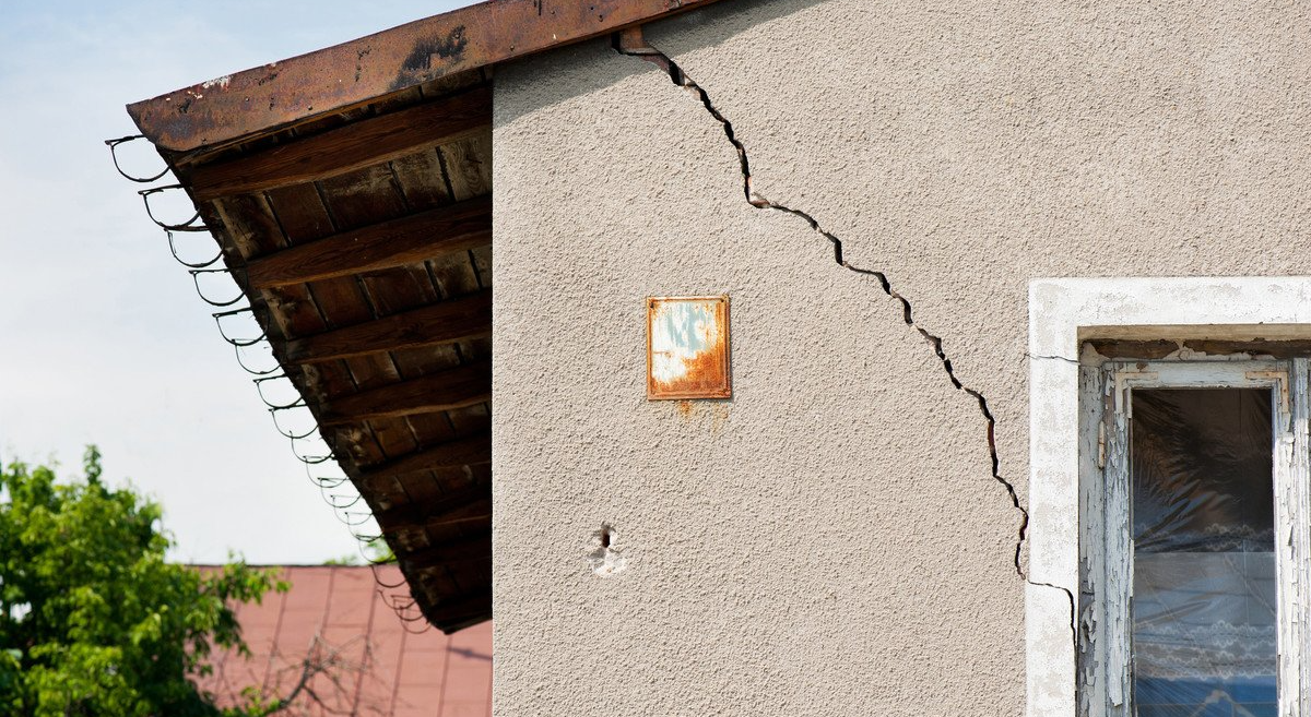 Fissure dans une maison allant du toit à la fenêtre