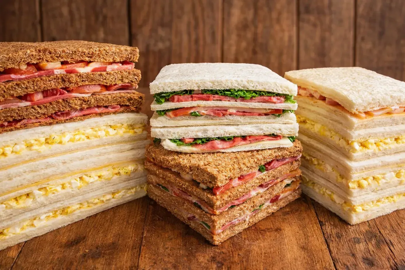 Vista de cerca de varios pasteles de chocolate exquisitos y un pastel glaseado expuestos en una vitrina de cristal 