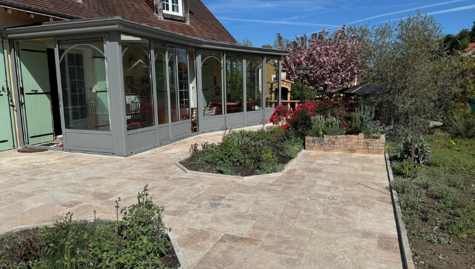 Terrasse en pierre donnant sur une véranda avec jardin.