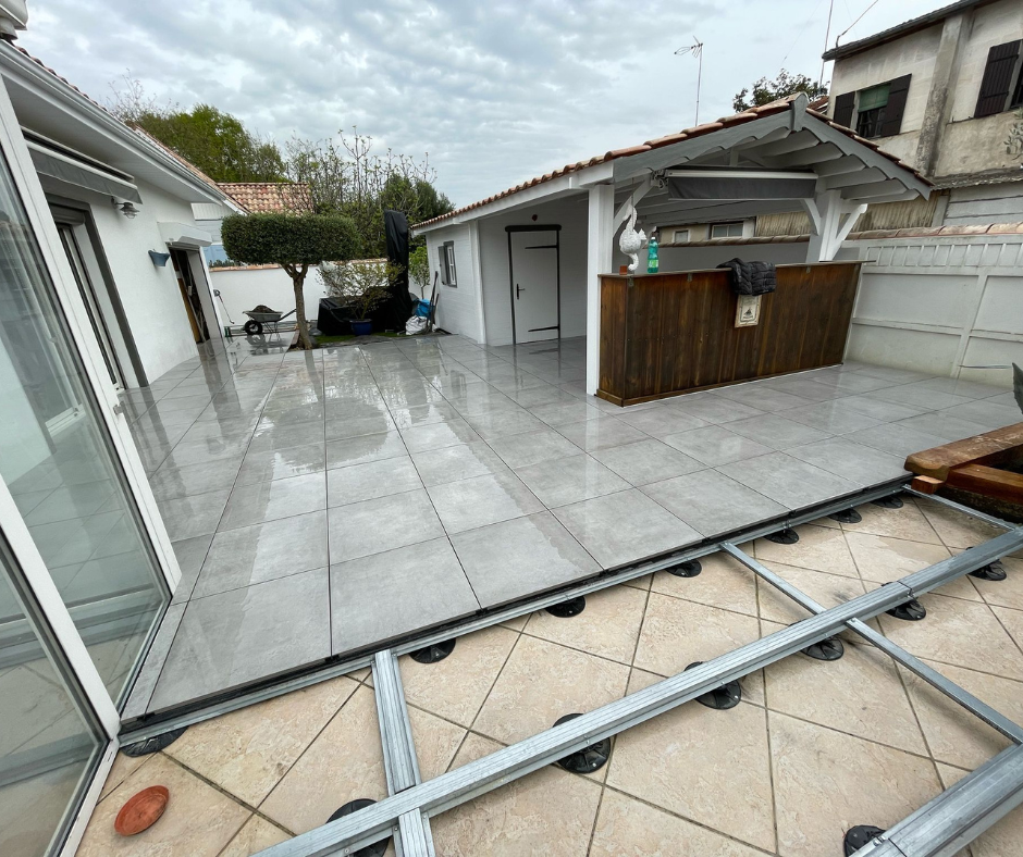 Une terrasse carrelée de gris avec une terrasse en construction.