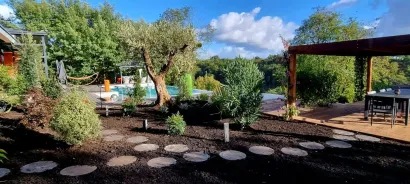 Chemin aménagé dans un jardin avec pergola et piscine.