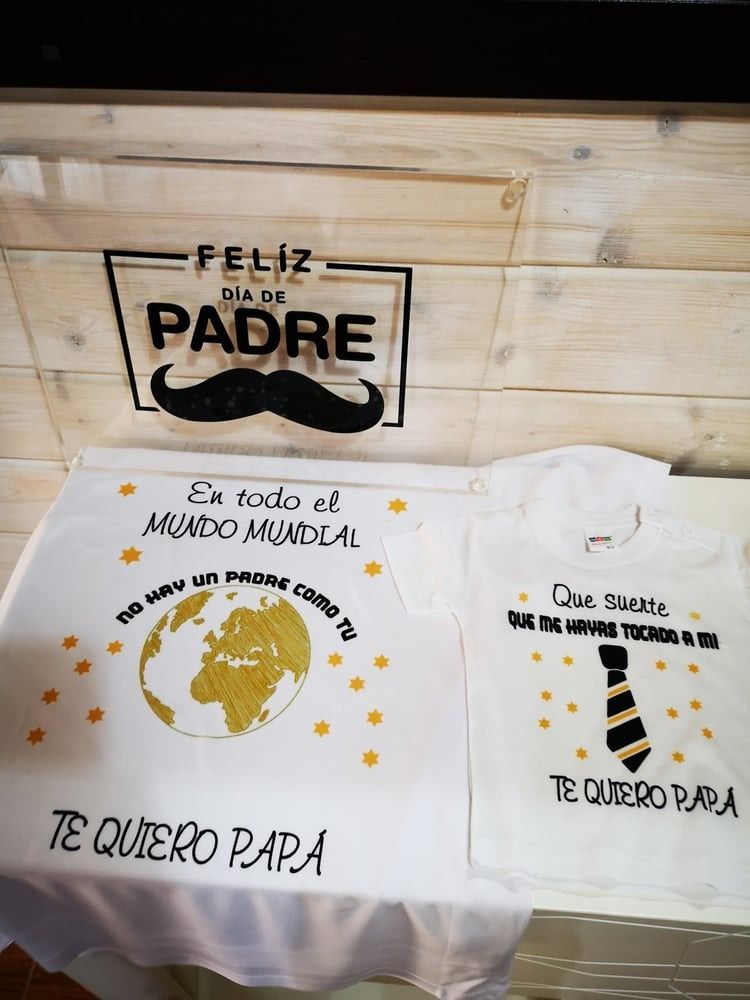Sobre una mesa hay dos camisas con bigote y corbata.