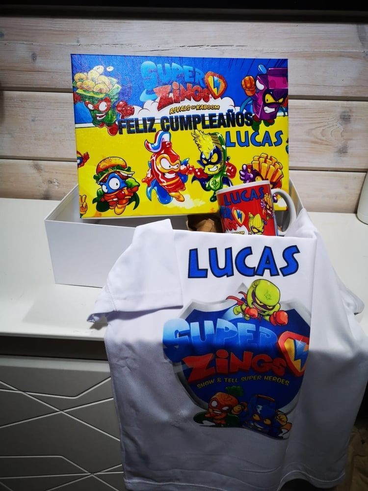 Una camiseta de Lucas reposa sobre una mesa junto a una caja.