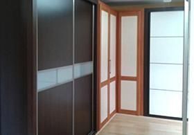 Un pasillo con puertas corredizas de vidrio y paredes de madera.