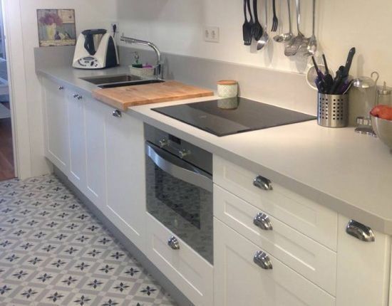 Una cocina con gabinetes blancos y un horno de estufa.