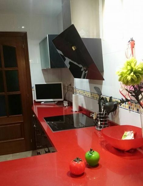 Una cocina con encimeras rojas y un horno de leña.