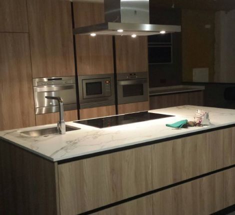 Una cocina con electrodomésticos de acero inoxidable y gabinetes de madera.