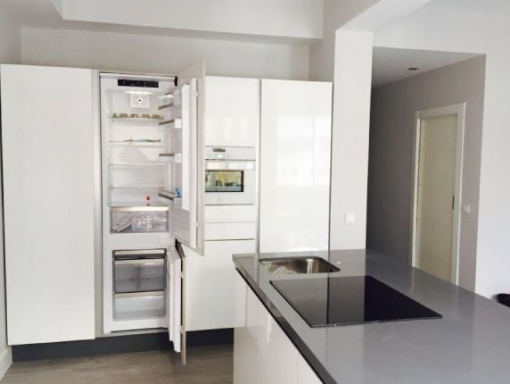 Una cocina con gabinetes blancos y un horno de estufa.