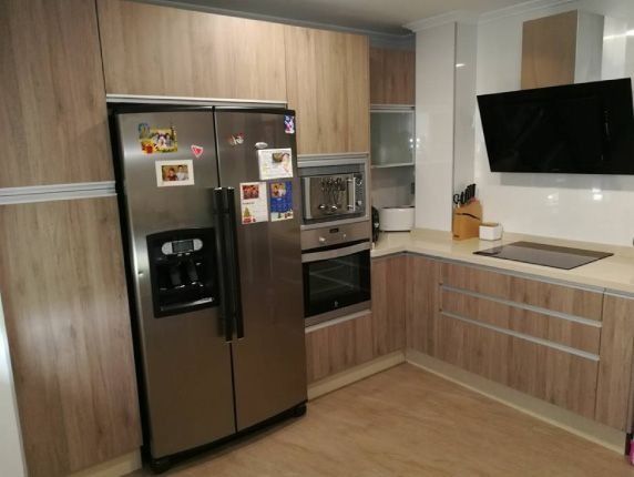 Una cocina con electrodomésticos de acero inoxidable y gabinetes de madera.