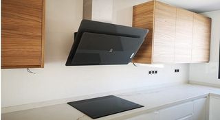 Una cocina con horno y campana extractora.