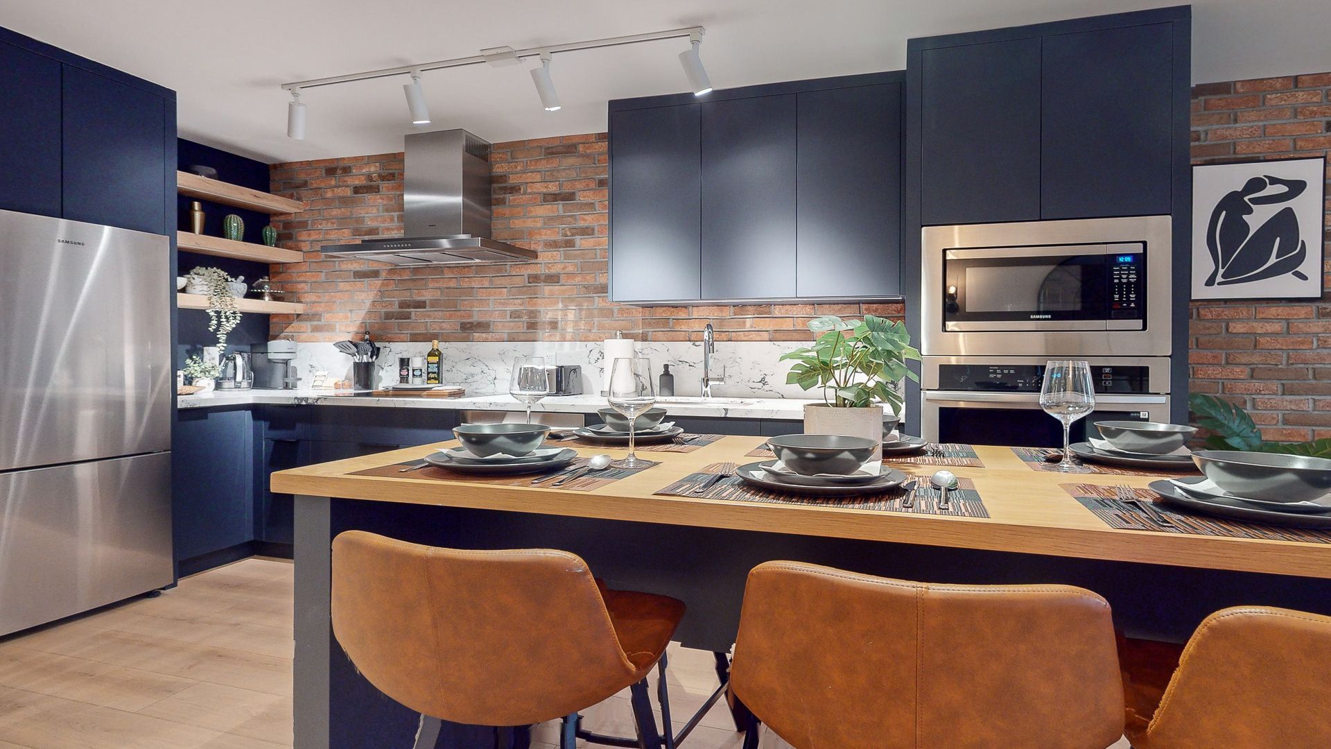 Living room with brick wall, cream sectional, yellow armchairs, and a fireplace.