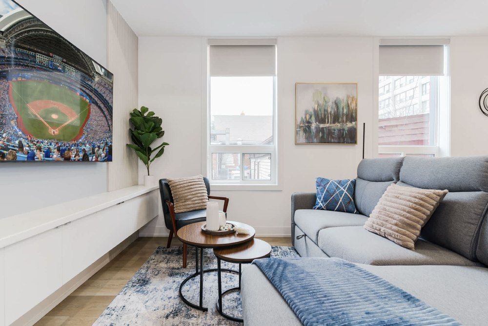 Living room with brick wall, cream sectional, yellow armchairs, and a fireplace.