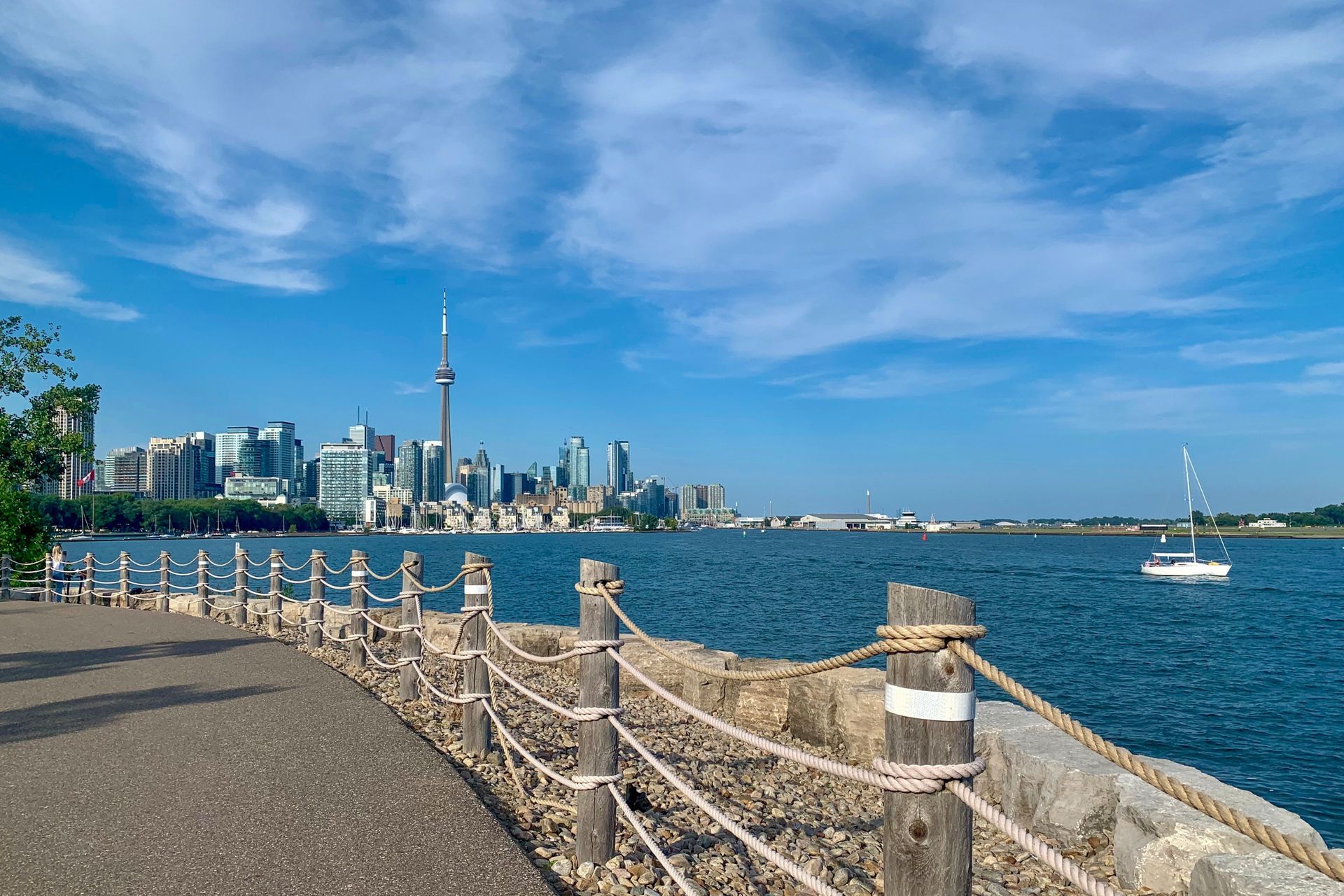 The iconic Toronto skyline rises above the calm waters of the lake as seen from the Waterfront Trail.