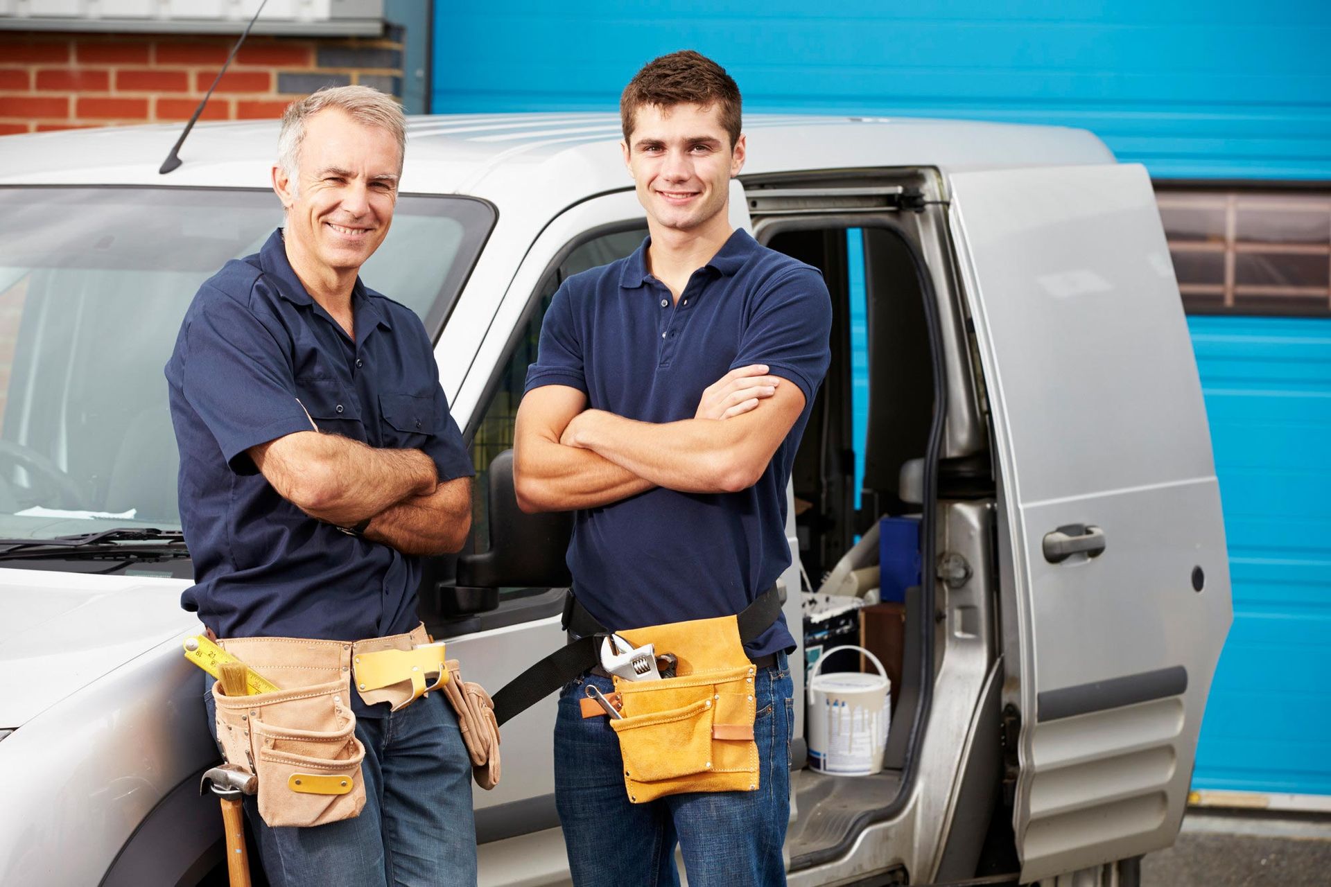Deux artisans en uniforme devant un camion
